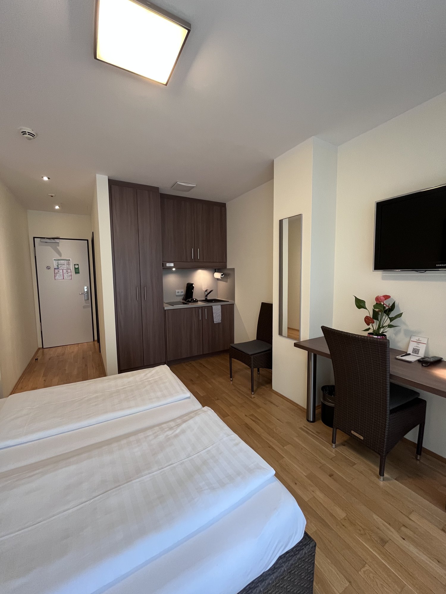 Studio mit Kitchenette, Kleiderschrank, Schreibtisch und Smart-TV